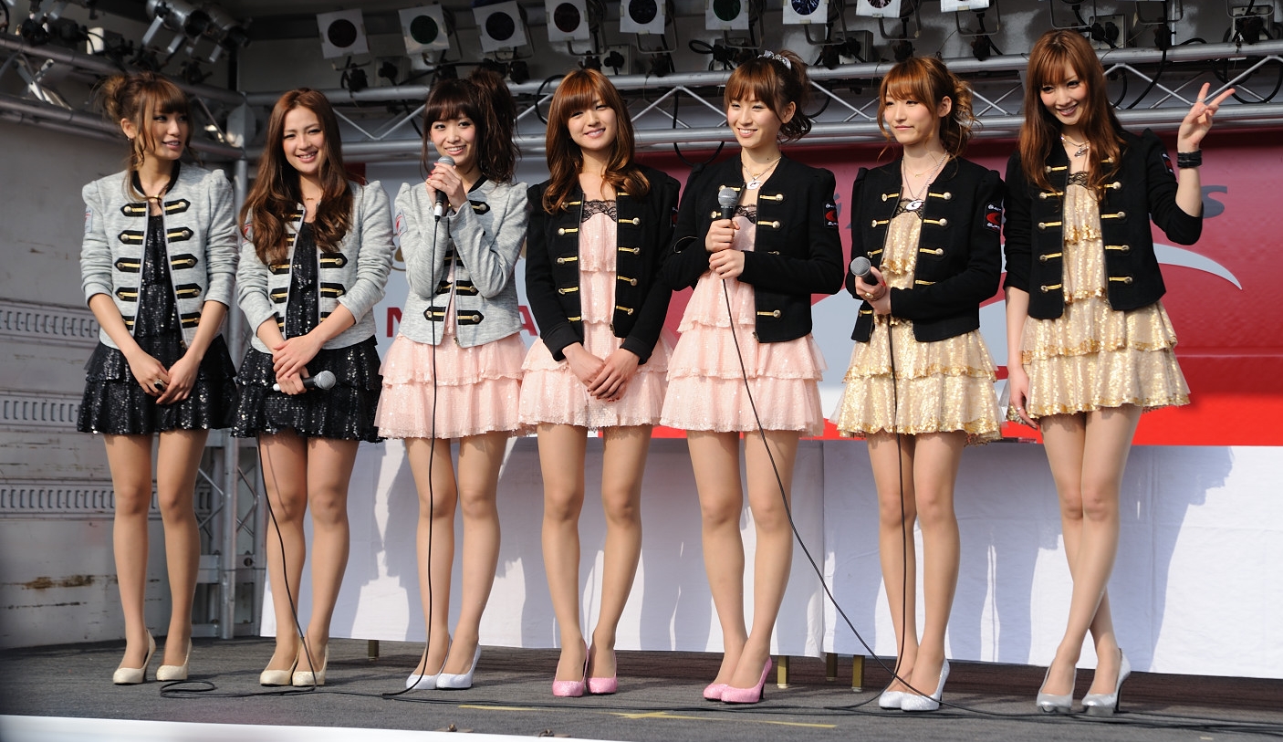 Seven Race Queens with Bare Legs wearing Pleated Short Dresses and Pink and White Stilettos